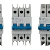 Three white circuit breakers with blue toggles. The middle one is a triple-pole slow blow circuit breaker, while the outer two are single-pole.