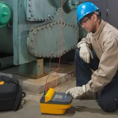 Technician uses a megohmmeter, a meter used to measure insulation resistance, on industrial equipment.
