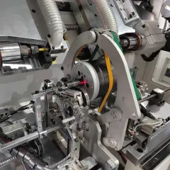 Precision machinery for electric motor balancing, featuring a spinning rotor with a red laser guide and automated arms.