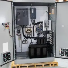 Inside an open electrical cabinet, a VFD drive cooling system with multiple fans is visible, alongside transformers and other components.
