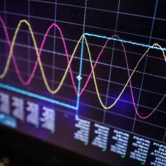 Oscilloscope screen showing three waveforms (pink, yellow, blue) and data readouts, illustrating signal integrity analysis.