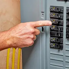 A finger points to a breaker switch, possibly indicating a breaker switch breakdown or a need for troubleshooting.