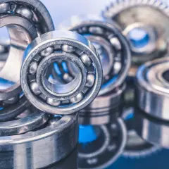 A close-up of several ball bearings, some with visible steel balls, on a reflective blue surface. These precision components, like glacier garlock bearings, are essential for smooth rotation.