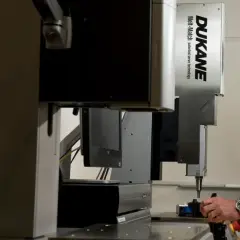 Man operating a Dukane Corporation Melt-Match ultrasonic welding machine.