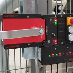 A red and silver Euchner MGB safety handle lock is mounted on a metal cage. The control unit shows green and red indicator lights.