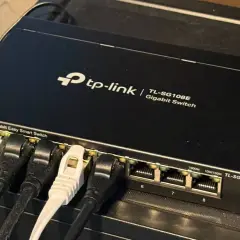 A TP-Link 8-port Gigabit Easy Smart Switch, a type of unmanaged ethernet switch, connects devices.