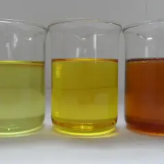 Three beakers contain liquids of varying shades of yellow and amber, representing different grades of iso oil.