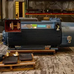 A large Siemens motor with its terminal box open, revealing wiring. Different motor enclosure types are visible in the background.