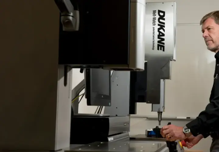 Man operating a Dukane Corporation Melt-Match ultrasonic welding machine.