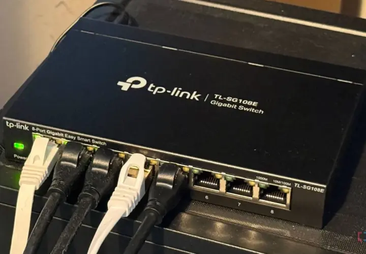 A TP-Link 8-port Gigabit Easy Smart Switch, a type of unmanaged ethernet switch, connects devices.