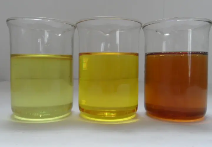 Three beakers contain liquids of varying shades of yellow and amber, representing different grades of iso oil.