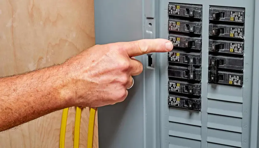 A finger points to a breaker switch, possibly indicating a breaker switch breakdown or a need for troubleshooting.