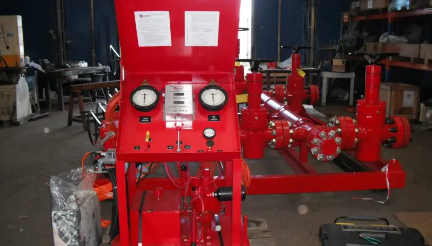 Red industrial equipment with gauges displaying pressure and flow velocity units.