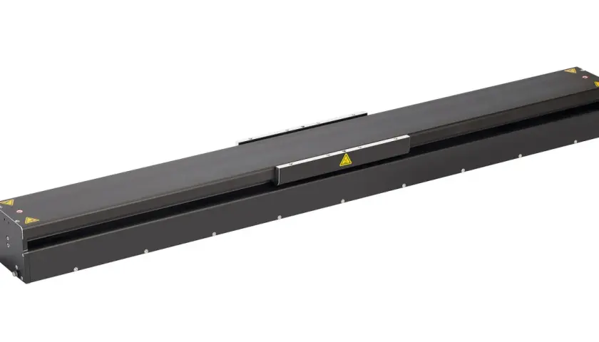 A long, black linear stage actuator with warning symbols.