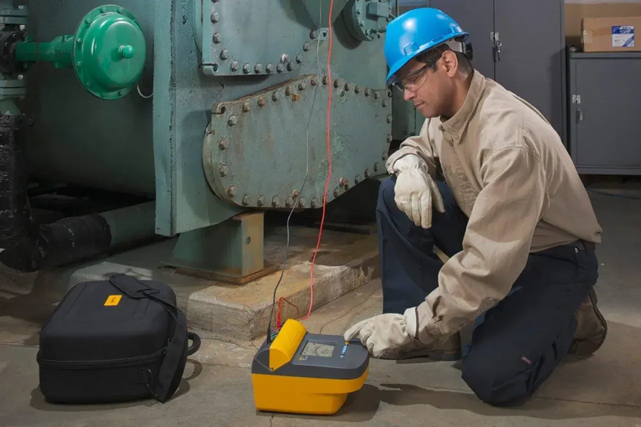 Technician uses a megohmmeter, a meter used to measure insulation resistance, on industrial equipment.