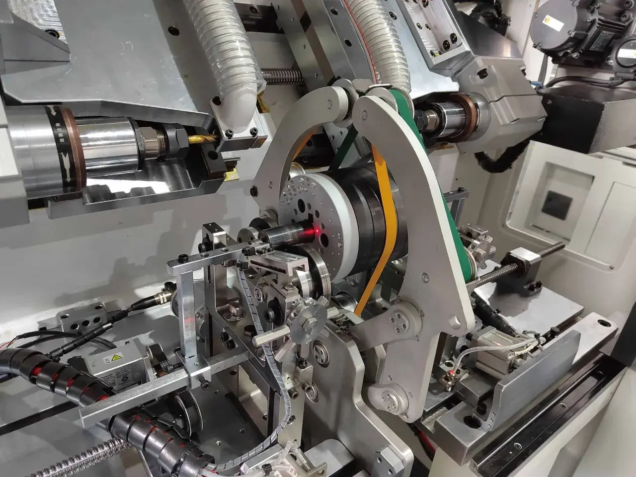 Precision machinery for electric motor balancing, featuring a spinning rotor with a red laser guide and automated arms.