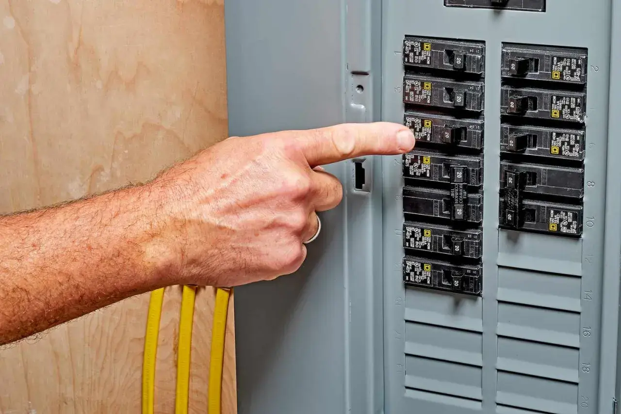 A finger points to a breaker switch, possibly indicating a breaker switch breakdown or a need for troubleshooting.