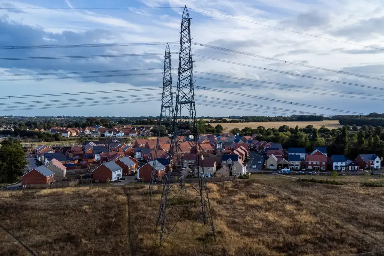 Power lines stretch over a new housing development, hinting at the distribution testing needed to power these homes.