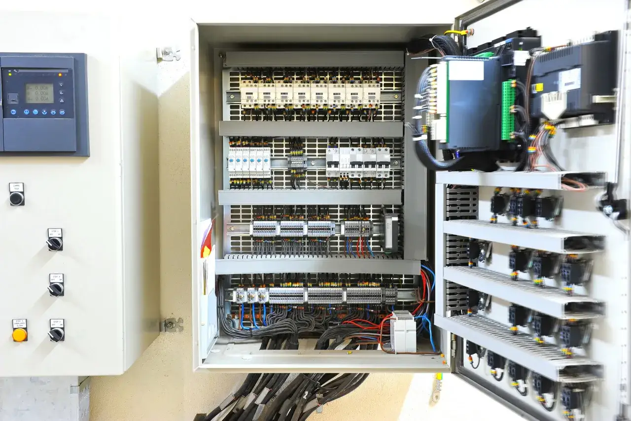 Inside an industrial electrical panel, rows of relays and circuit breakers are neatly wired. Special enclosures are required to protect motor controllers from corrosion.