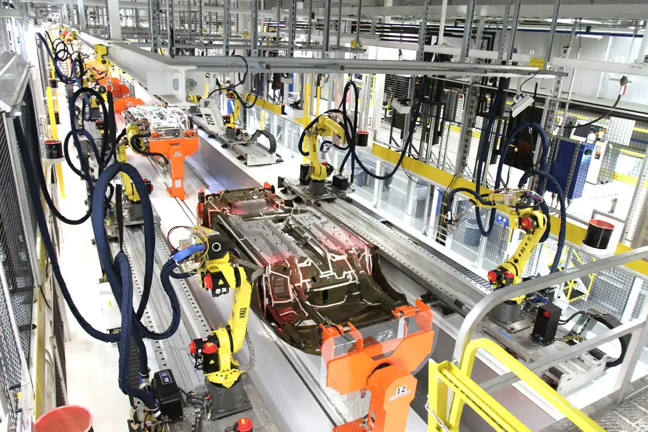 Robotic arms with heavy duty motor capabilities work on a car chassis assembly line.