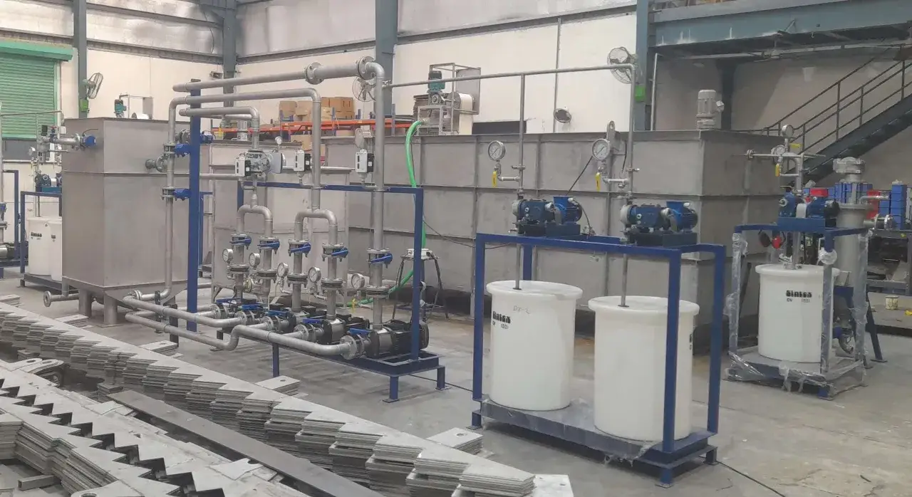 A complex industrial pump skid system with multiple pumps, tanks, and piping, likely for chemical processing.