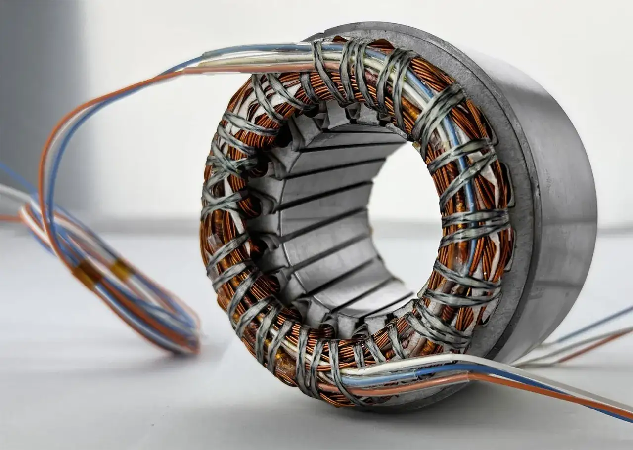 Close-up of a motor stater with copper windings and colorful wires, ready to power a new invention.