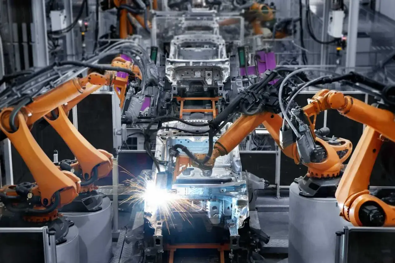 Robotic arms perform welding on a car chassis on an assembly line, showcasing advanced fori automation.